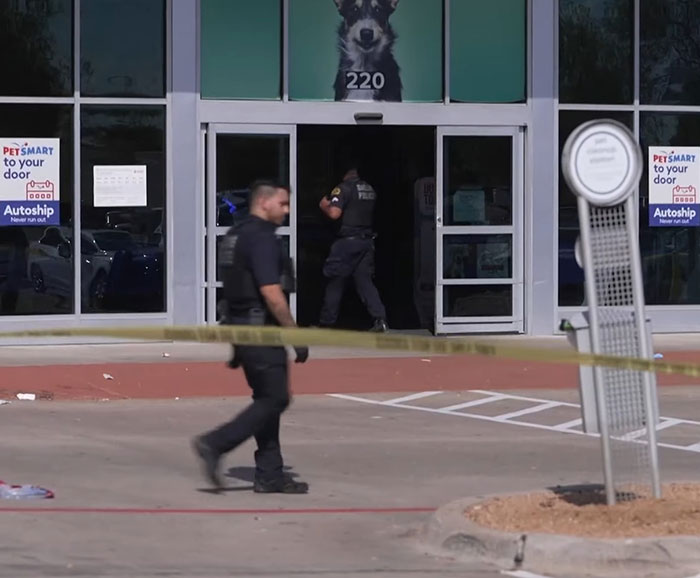Police officers secure the area outside a pet store after a woman loses life following an argument at the scene.