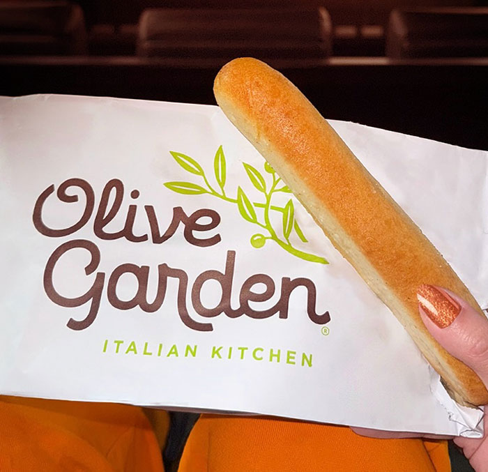 Olive Garden breadstick held by a person, highlighting the popular restaurant in a viral student hoax story. Olive Garden breadstick held by a person, highlighting the popular restaurant in a viral student hoax story.