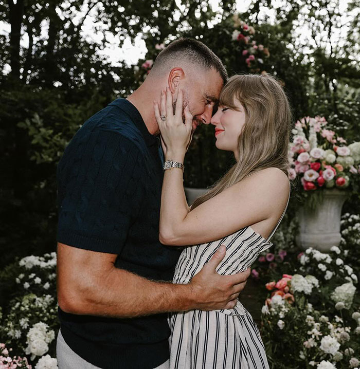 Couple embracing in a garden filled with flowers, relating to Tradwife and Taylor Swift fans reacting after Travis Kelce autograph.
