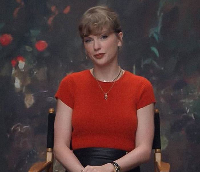 Taylor Swift seated in a red top during an interview about the mom of her late friend breaking silence after 15 years.
