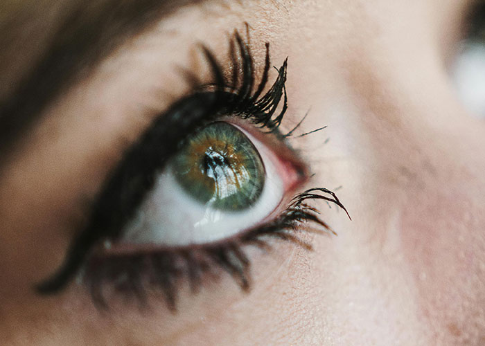 Close-up of an eye with long eyelashes, highlighting beauty details related to cosmetic procedure outcomes.