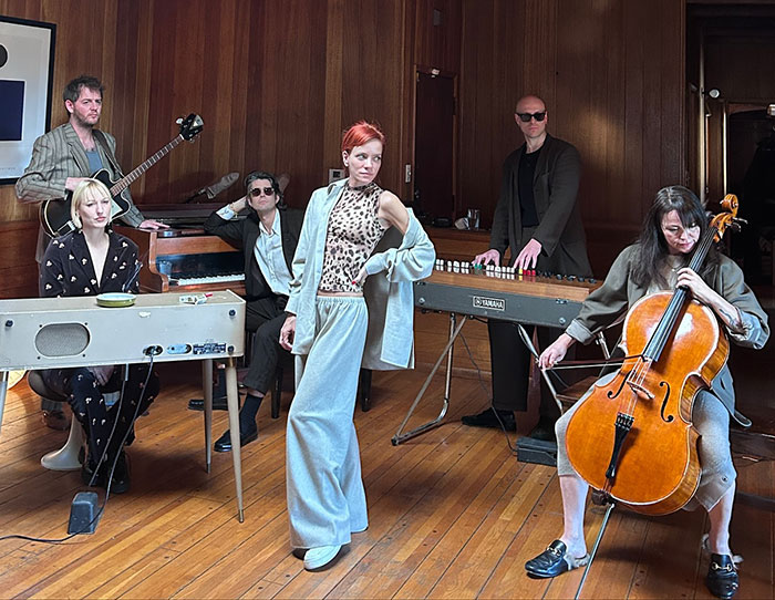 Group of musicians performing indoors with David Harbour&rsquo;s friend responding to Lily Allen&rsquo;s vile accusations.