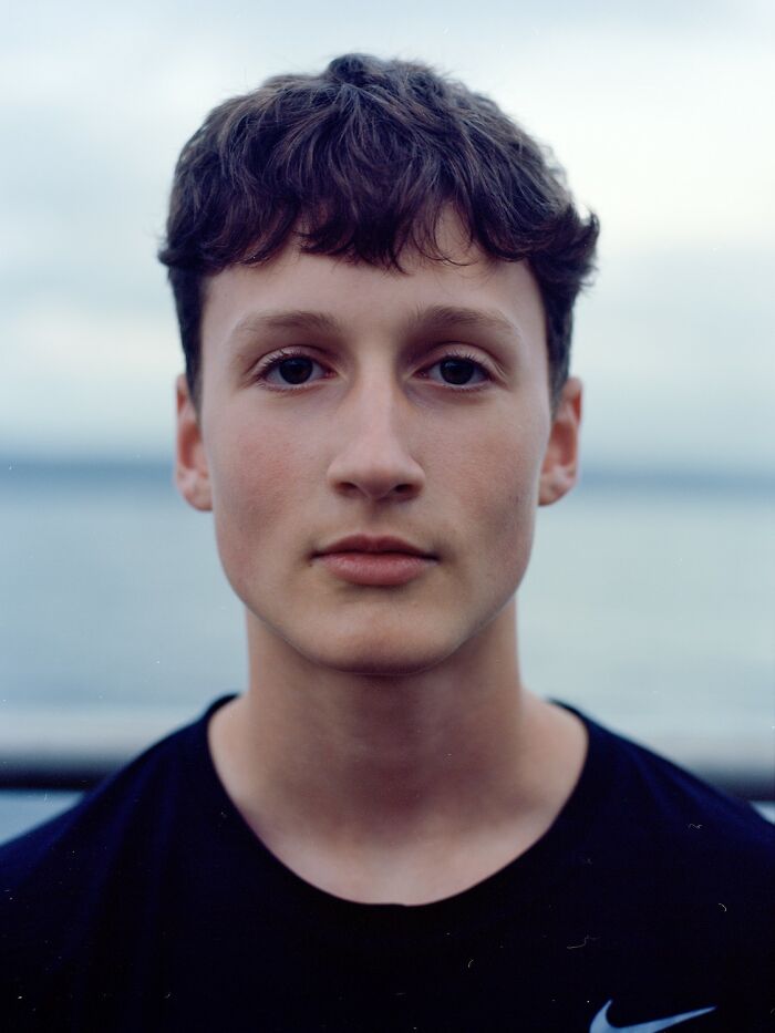 Young woman with freckles wearing a red and beige jacket, featured in award-winning photos from the 2025 Photographer of the Year contest