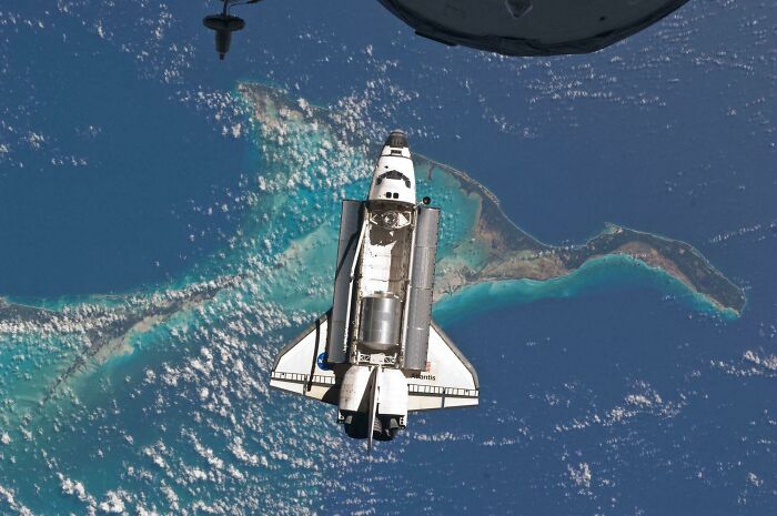 Space shuttle orbiting Earth with clear view of ocean and islands, showcasing epic astronomy and the mystery of space.