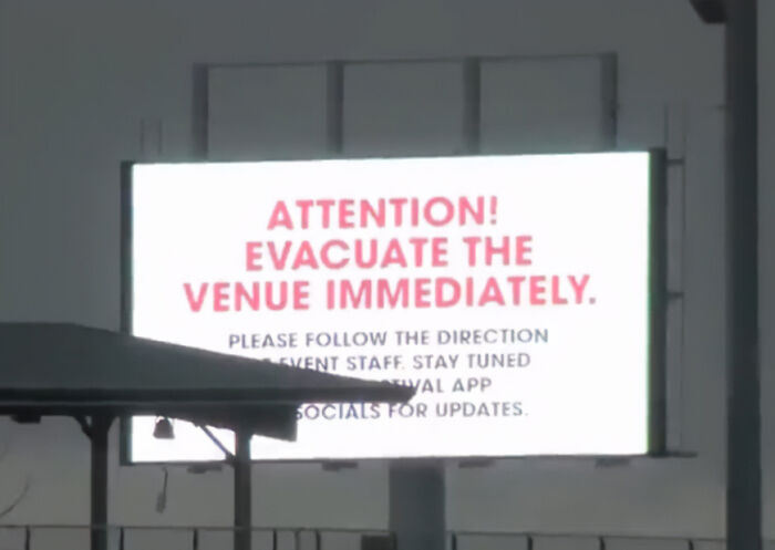 Digital sign at music festival instructing immediate evacuation following a freak accident involving a woman attending to see Post Malone.