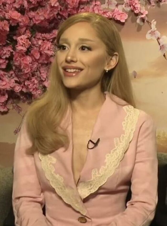 Young woman in a pink blazer being interviewed with floral background, related to celebs people can't stand discussion.