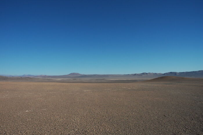 Vast barren desert landscape under clear blue sky illustrating incredible weather records on our planet.