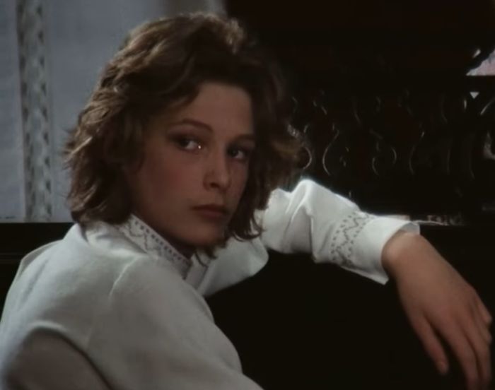 Young actor known as the most beautiful boy in the world, shown in a vintage film scene with a contemplative expression.