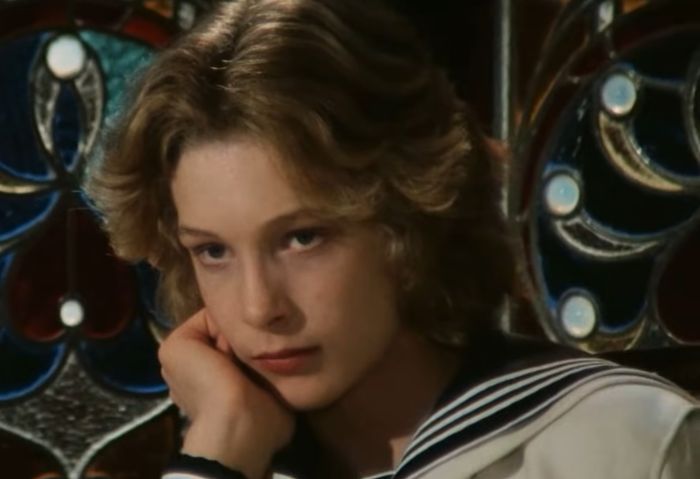 Young actor known as the most beautiful boy in the world, appearing thoughtful in a vintage sailor outfit.