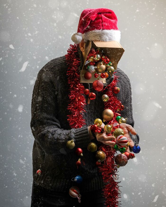 Person wearing a Santa hat with a box on their face filled with Christmas ornaments, showcasing amazing logic-challenging photo manipulation.