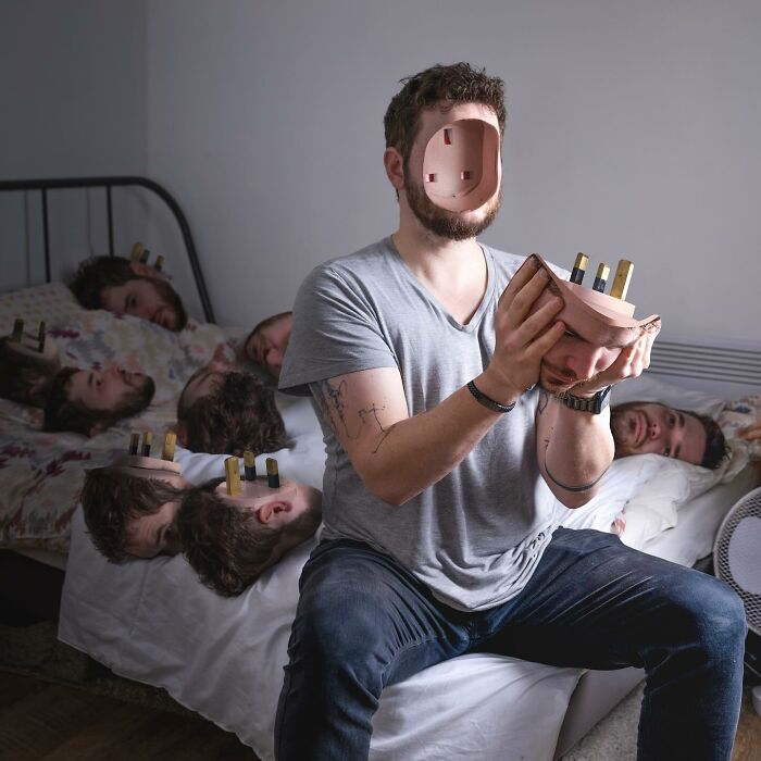 Man with logic-challenging photo manipulations sits on bed holding a hollowed-out face with multiple heads lying on the bed.
