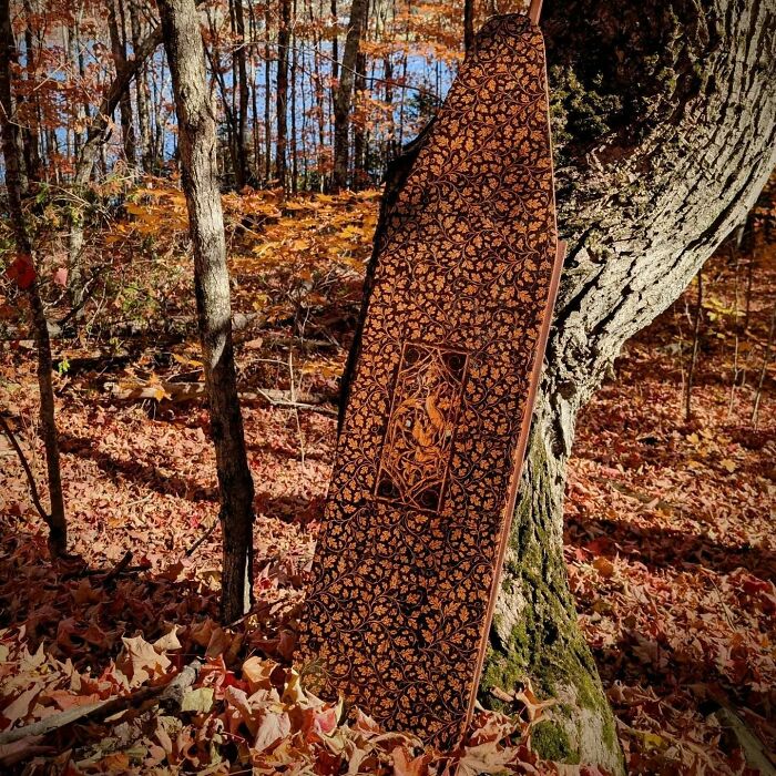 Wood-burned artwork by Canadian artist Kat Slota, showcasing detailed fire-created patterns on a wooden piece outdoors.