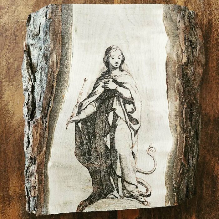 Wood-burned artwork of a cloaked figure on natural bark, created using fire by Canadian artist Kat Slota.
