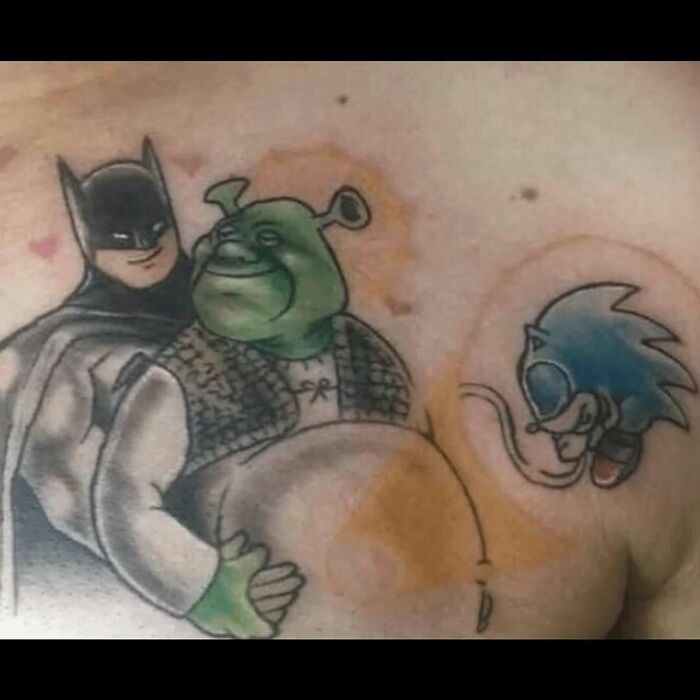 Tattoo featuring Batman hugging Shrek with Sonic the Hedgehog nearby, showcasing some of the worst tattoo choices.