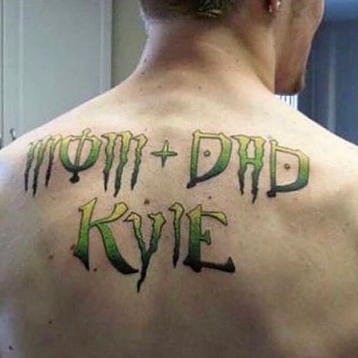 Tattoo on a man's back with the words mom + dad and the name kylie in a green and black gothic style.