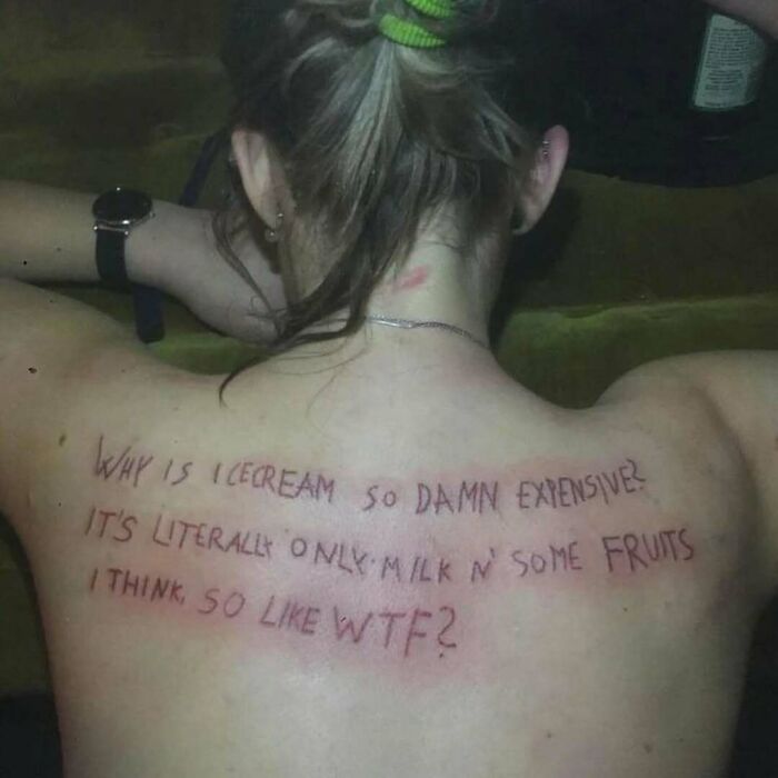 Person with a tattoo of a confusing message about ice cream on their back, showcasing awful tattoos and bad decisions.