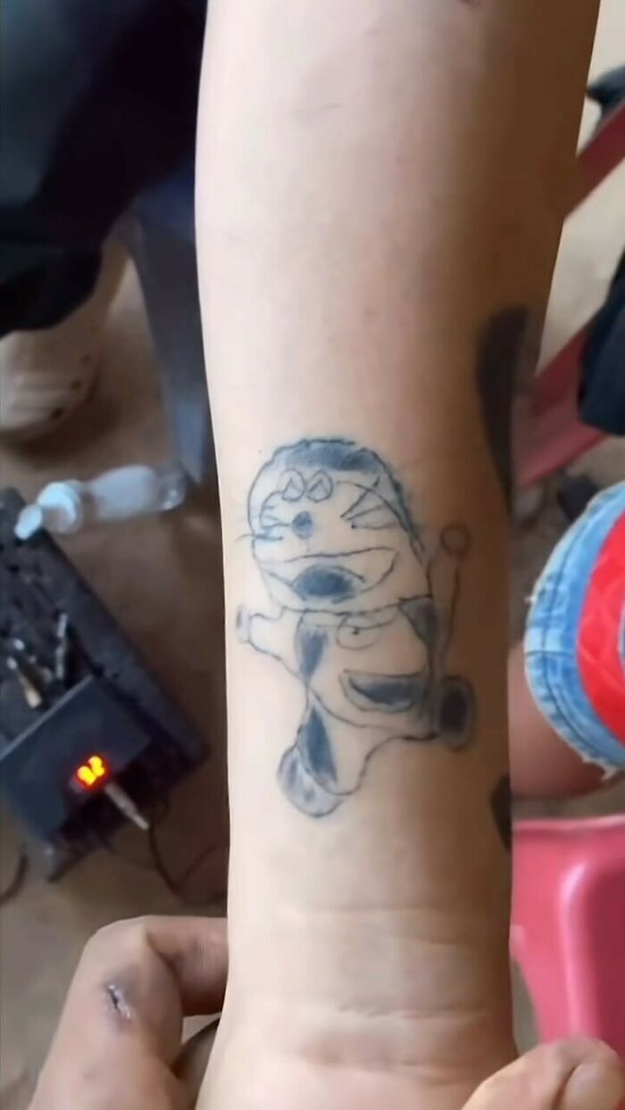 Close-up of an awkwardly drawn tattoo on a forearm showcasing one of the awful tattoos from a questionable decision.