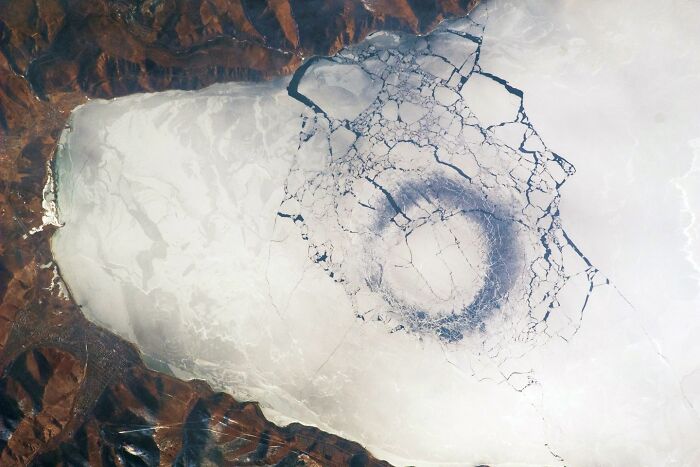 Aerial view of a large circular pattern in an icy ocean area, showcasing weird and fascinating ocean phenomena.