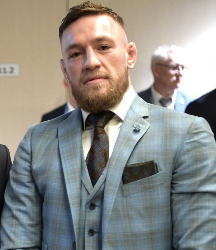Confident man in a checkered suit with a beard, representing moments people were disappointed in someone idolized.