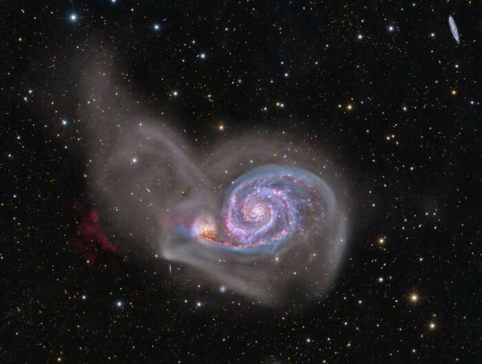 Spiral galaxy glowing with colorful gases and stars surrounded by dark space in epic astronomy photos of the universe.
