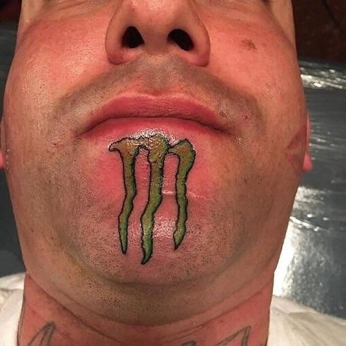 Man with an awkward green claw-like tattoo on chin, showcasing one of the most awful tattoos with poor decision making.