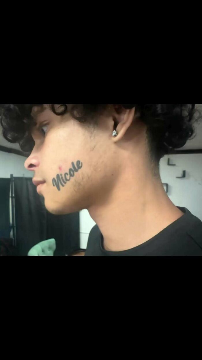 Young man with an awkward face tattoo reading Nicole on his cheek, one of the awful tattoos showing poor decisions.