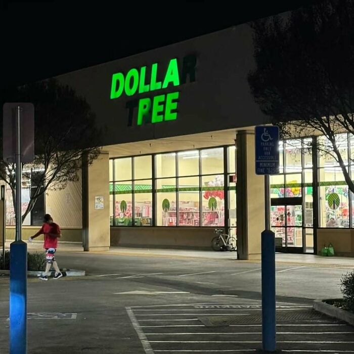 Doll store sign partially unlit at night showing the words dolla and pee, a humorous image that might need a priest or exorcist.