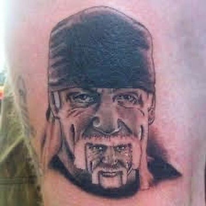 Tattoo of a man's face wearing a bandana with a smaller, distorted face inked on the chin, an example of awful tattoos.