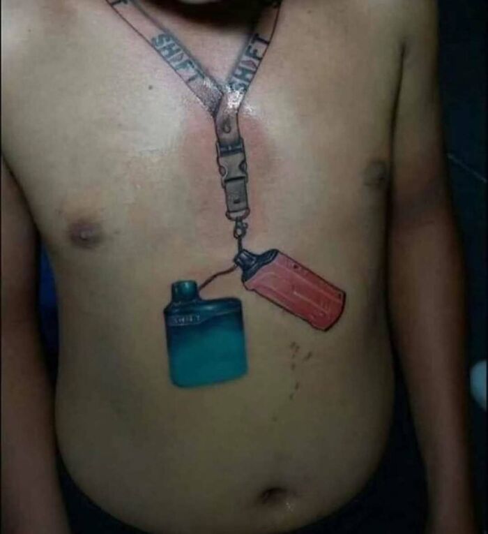 Tattoo of a lanyard with hand sanitizer and a red bottle on a man's bare chest, an example of awful tattoos.