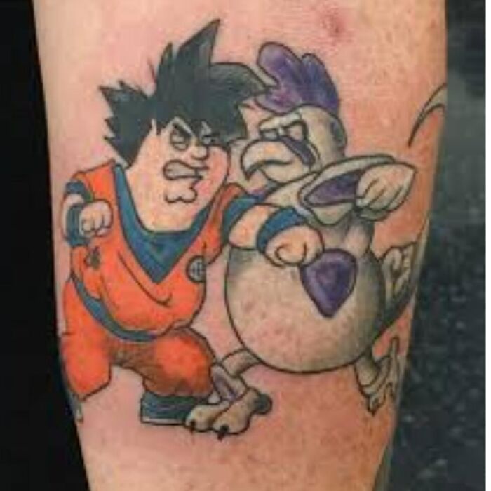 Tattoo of a poorly drawn cartoon character in an orange outfit fighting an angry bird, showcasing awful tattoos and bad decisions