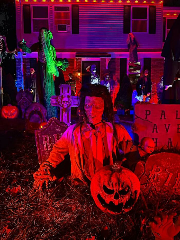 Halloween outdoor decorations featuring creepy skeletons, tombstones, and glowing jack-o-lanterns in a spooky yard display.