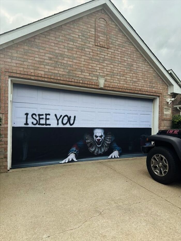 Garage door Halloween decoration with scary clown and graffiti text I SEE YOU as outdoor Halloween decoration pride.
