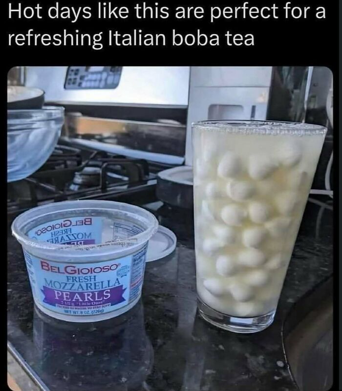 Glass filled with fresh mozzarella pearls and liquid on kitchen counter, creating a bizarre image needing a priest or exorcist.