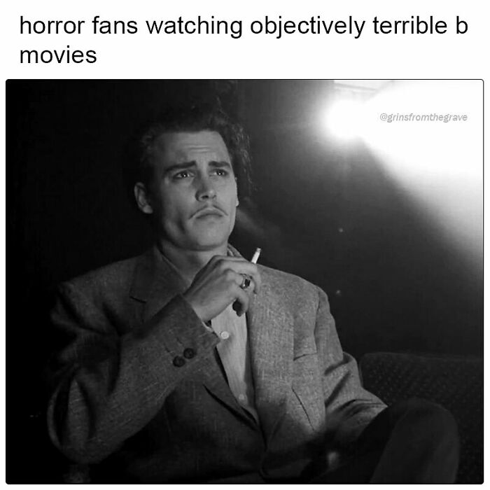 Black and white photo of a man in a suit smoking a cigarette, captioned about horror fans watching terrible B movies meme.