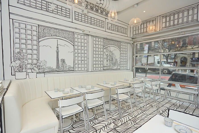 Interior of a 2D restaurant in NYC with black and white drawing-style walls, floors, and furniture creating a flat art effect. Interior of a 2D restaurant in NYC with black and white drawing-style walls, floors, and furniture creating a flat art effect.
