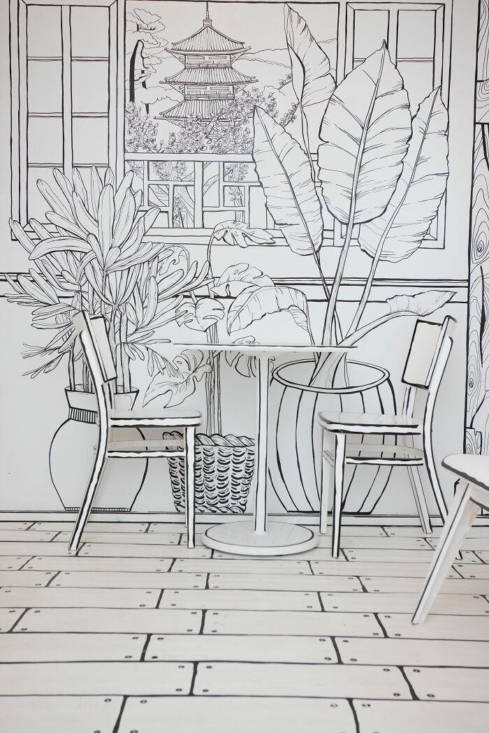 Interior of a 2D restaurant in NYC with black and white hand-drawn style furniture and wall art creating a drawing effect. Interior of a 2D restaurant in NYC with black and white hand-drawn style furniture and wall art creating a drawing effect.