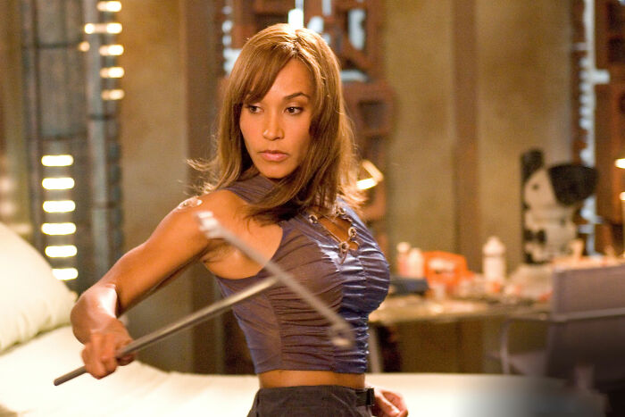 Woman in a movie scene holding a weapon showing one of the most unrealistic women movie tropes still annoying viewers today.