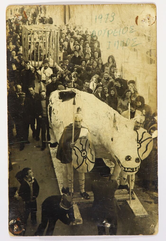Vintage Halloween costumes with a large eerie creature and people dressed as ancient warriors in a crowd parade.