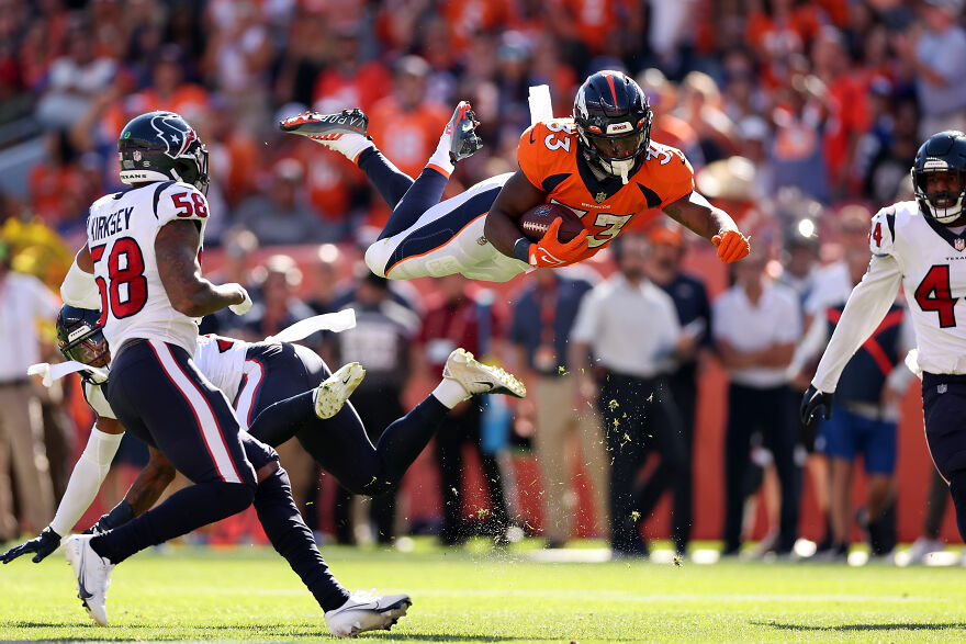 Denver Broncos player diving while holding ball during football game, highlighting Jonathan Owens net worth growth in sports. Denver Broncos player diving while holding ball during football game, highlighting Jonathan Owens net worth growth in sports.