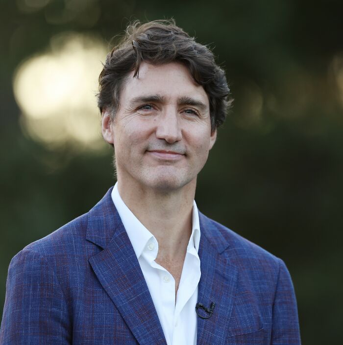 Justin Trudeau in a blue suit outdoors, related to news on Katy Perry and his romance following ex-wife's message.