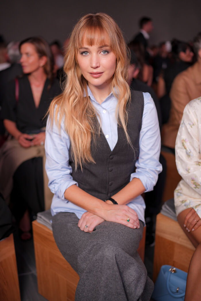 Jennifer Lawrence at Paris Fashion Week, sparking frenzy and discussions about plastic surgeons in LA.