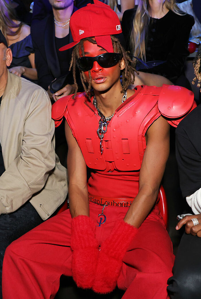 Jaden Smith in red face paint and outfit with oversized mittens and a cap, showcasing a unique Paris fashion look. Jaden Smith in red face paint and outfit with oversized mittens and a cap, showcasing a unique Paris fashion look.