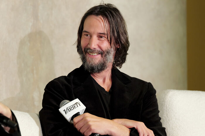Keanu Reeves smiling during a Variety interview, discussing media reactions and guest experiences.