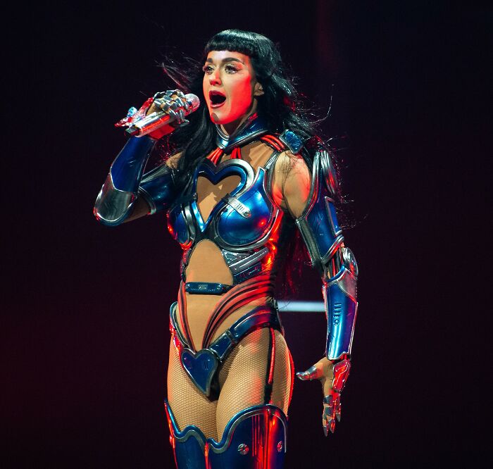 Katy Perry performing on stage in a futuristic metallic outfit amid rumors of romance with Justin Trudeau.