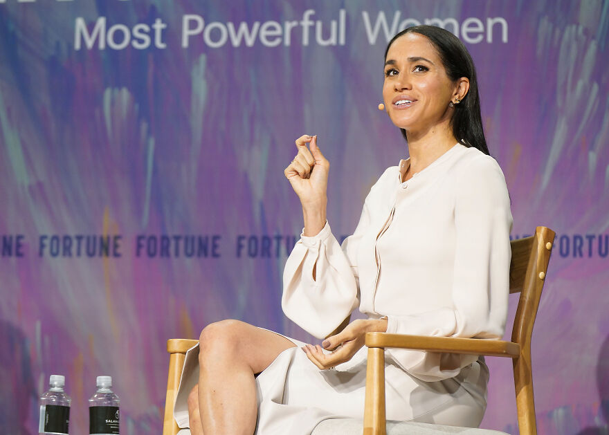 Meghan Markle speaking at an event, wearing a white dress, relating to Meghan Markle net worth in 2025 discussion. Meghan Markle speaking at an event, wearing a white dress, relating to Meghan Markle net worth in 2025 discussion.