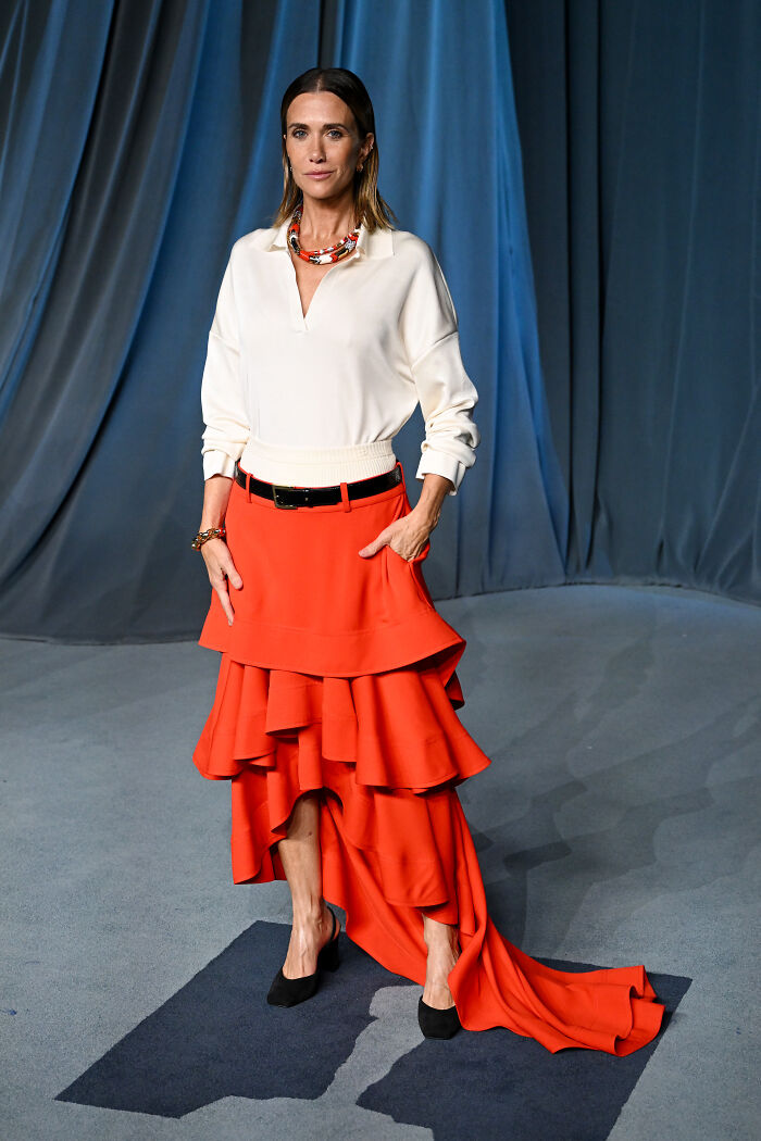 Woman posing in a layered red skirt and white blouse showcasing must-see looks from the 2025 Academy Museum Gala red carpet.