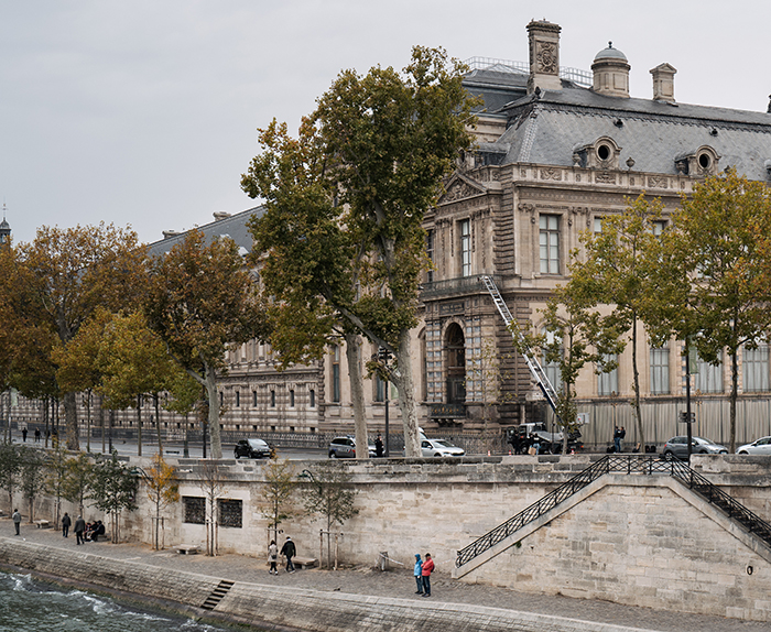 The Louvre Museum exterior with trees and pedestrians, linked to America&rsquo;s most notorious jewel thief and smuggling tricks.