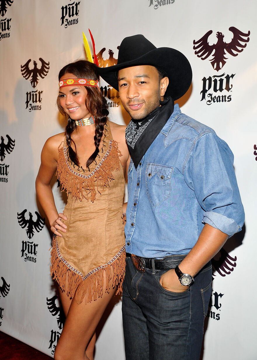 Couple in Halloween costumes at an event showing celebrities without common sense in their costume choices.