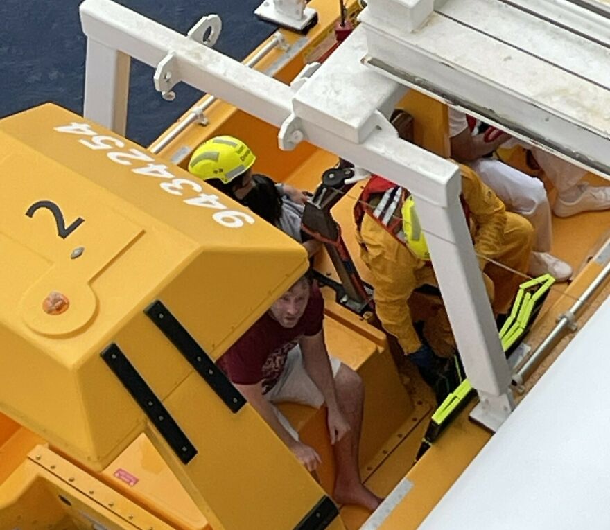 Rescue team assisting passengers in a yellow lifeboat after a girl's terrifying plunge into ocean from Disney cruise ship.