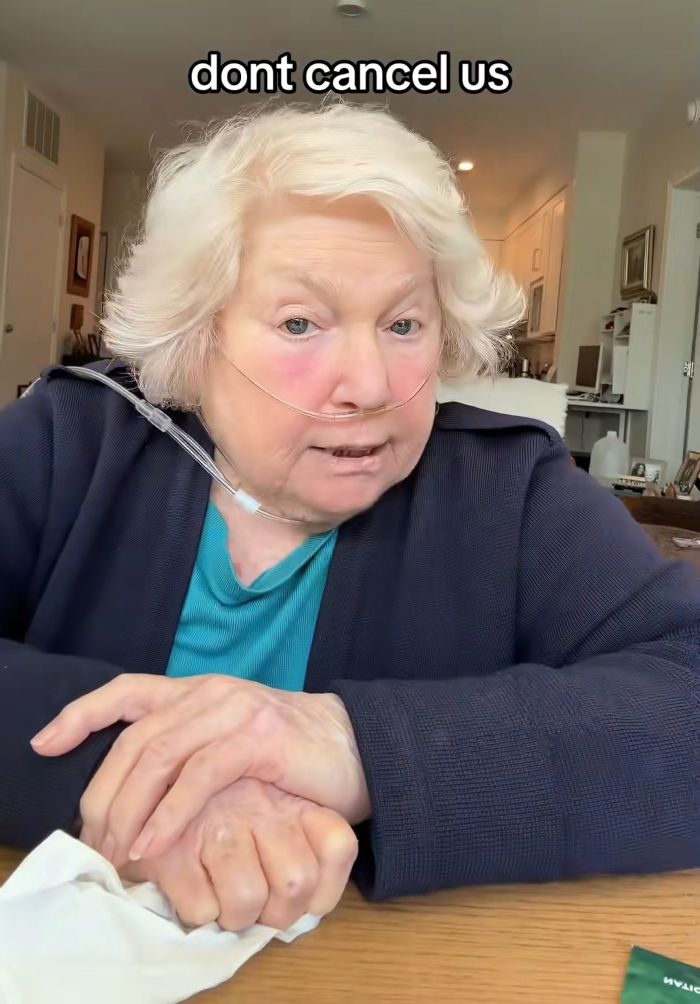 Elderly woman with oxygen tube sitting at a table, expressing concern, related to grandmother lockbox story.